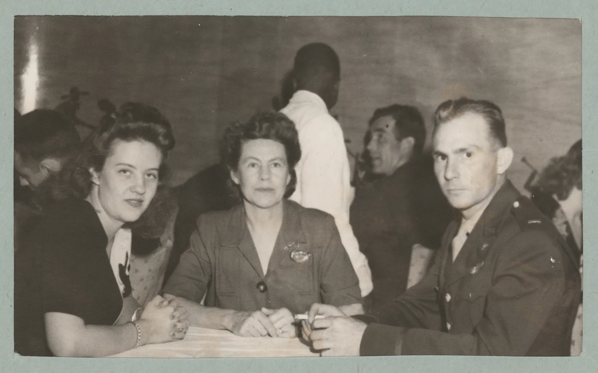 This photograph depicts Jean McKinstry Allison, Loveta McKinstry, and Harold Allison while at the Camellia Room at Hotel Savannah in Savannah, Georgia. This photograph was likely taken during the period that Jean traveled with Harold during his military training. This photograph is housed in a small folder that shows that it was received from Hotel Savannah.