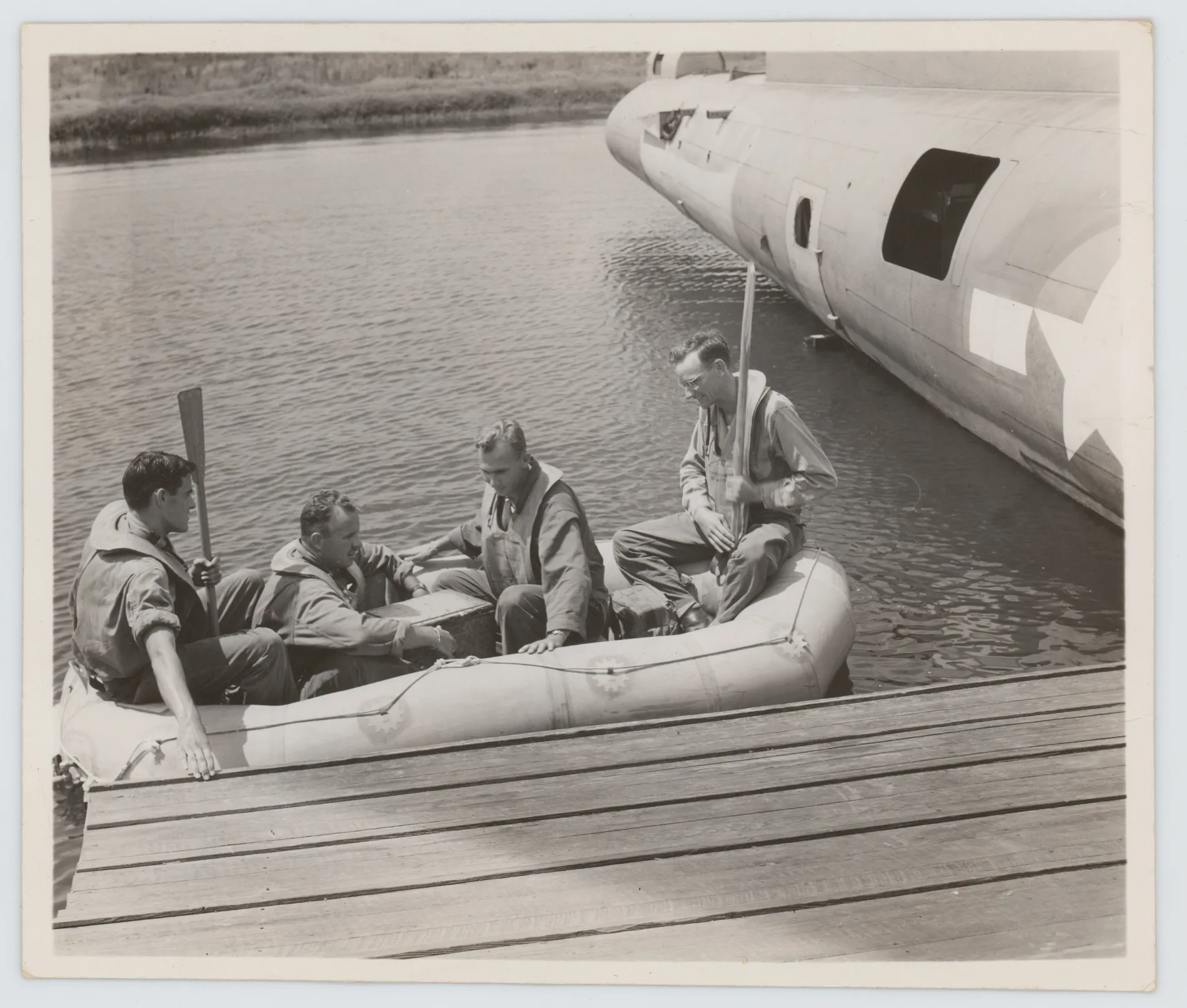 This photograph depicts Harold Allison training with three others to evacuate a B-17. This was likely taken during Harold's time training to fly a B-17.