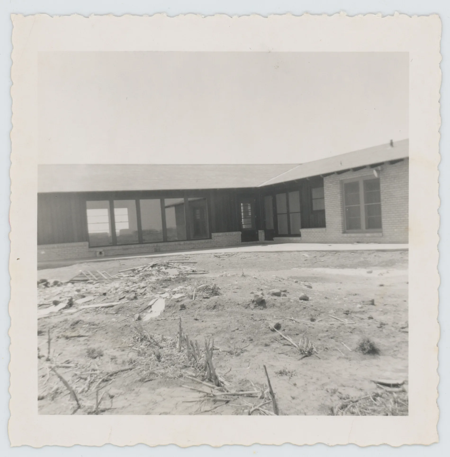 This photograph shows the home of Harold and Jean Allison either at the end of construction or just prior to the Allisons moving in. This view was taken from what became the backyard facing south and southwest.
