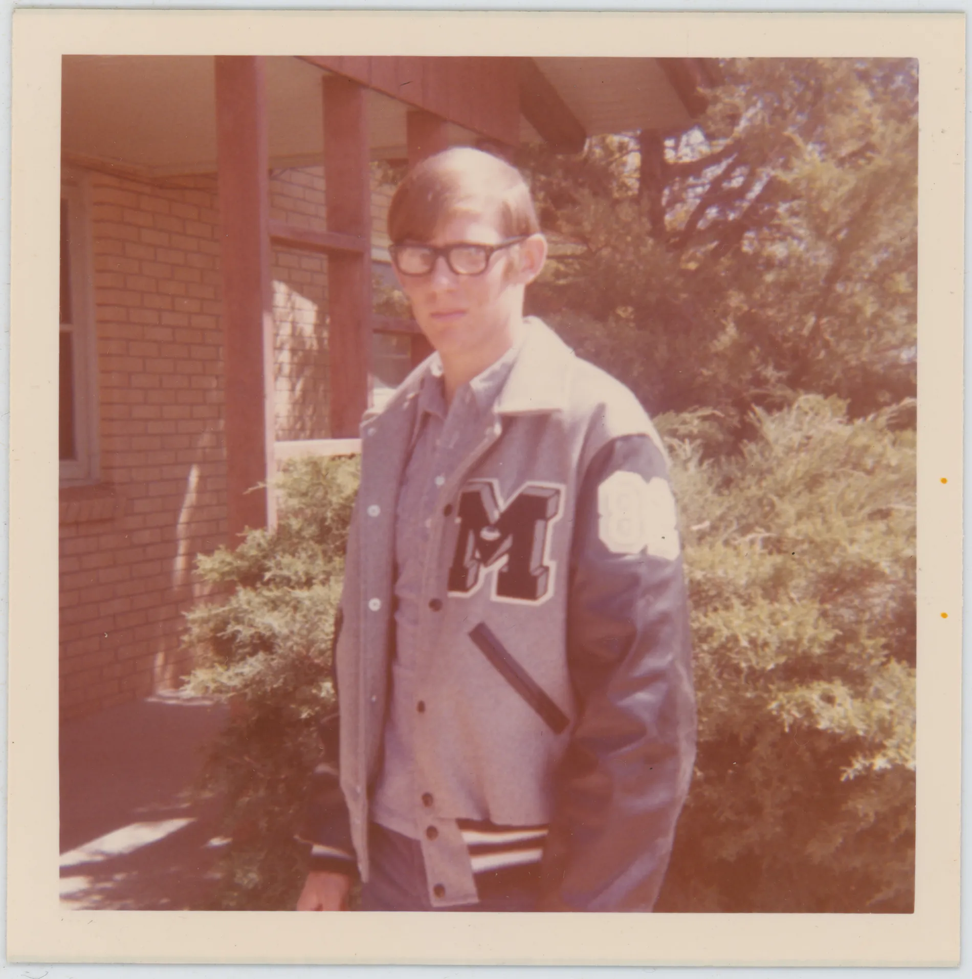 This photograph depicts Jack standing in front of his Lamb County home wearing his Muleshoe High School letterman jacket.