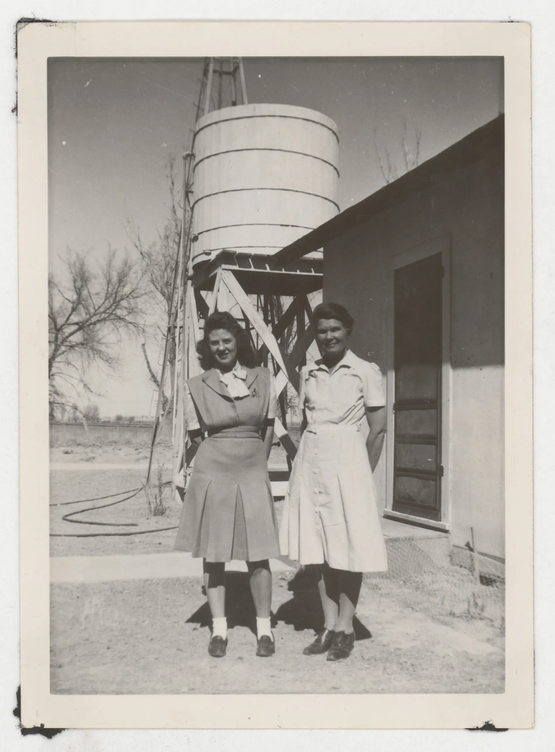 This photograph depicts Jean Allison and Ollie Grizzle standing next to a water tower.