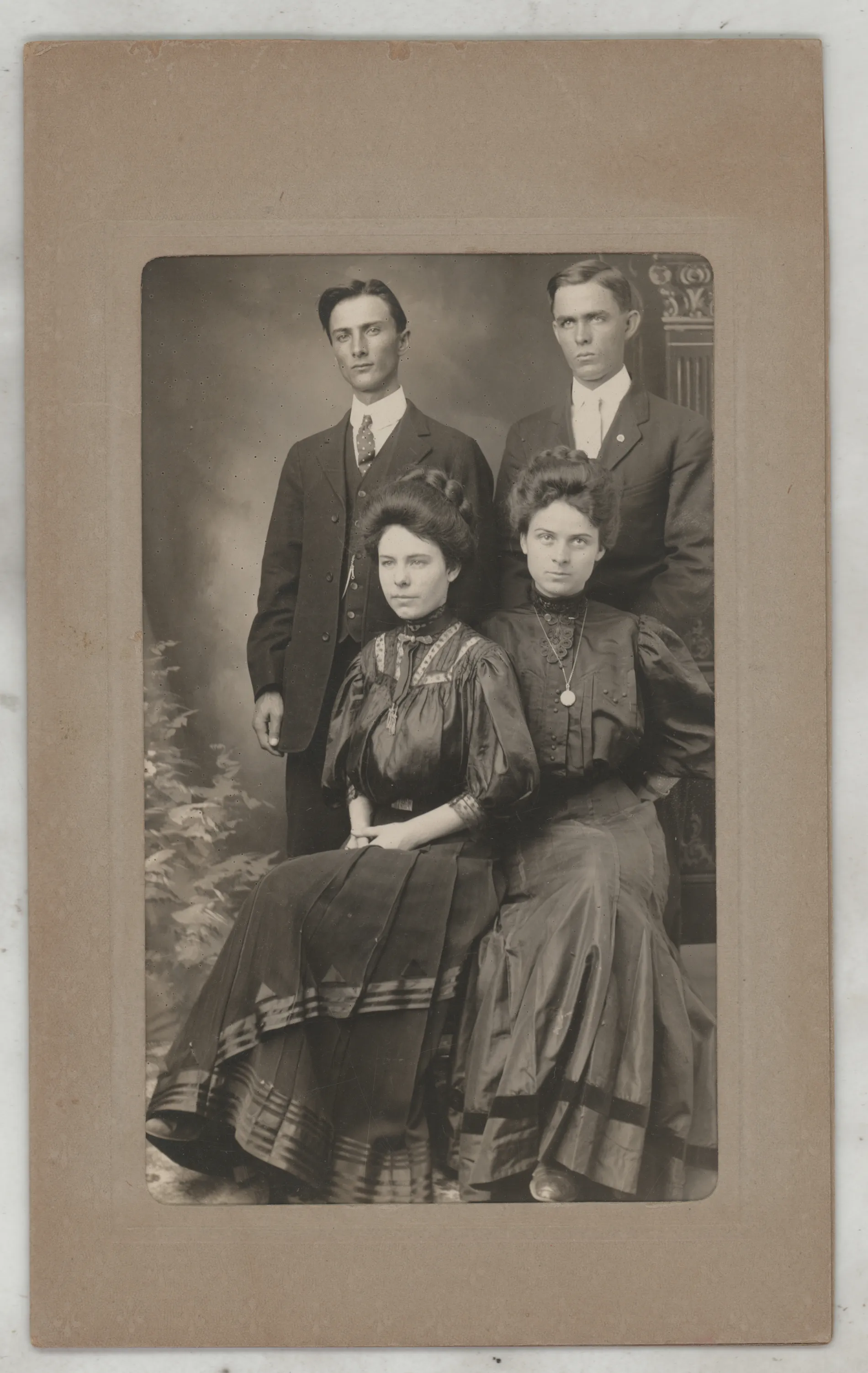 This is a formal portrait of Joseph Carroll Allison and his wife Sarah. They are joined by friend Ned Hogan and his wife Mary Melvin Pattonn Hogan. The photographs from this set are misidentified on the versos. They were sent to Harold Allison represented as photos of his father, Oscar, but it was determined this was not the case. They were then reidentified as Oscar's brother William Irvin Allison, but that was also found to be incorrect. After searching newspapers associated with Joseph Carroll's time in Dickens County as a teacher, Ned Hogan was identified as a friend he traveled with. His findagrave.com entry displays a picture of him that matches the likeness in these photographs. Despite Ned's appearance as an Allison, he is not, which provided quite the journey in identifying this photograph!