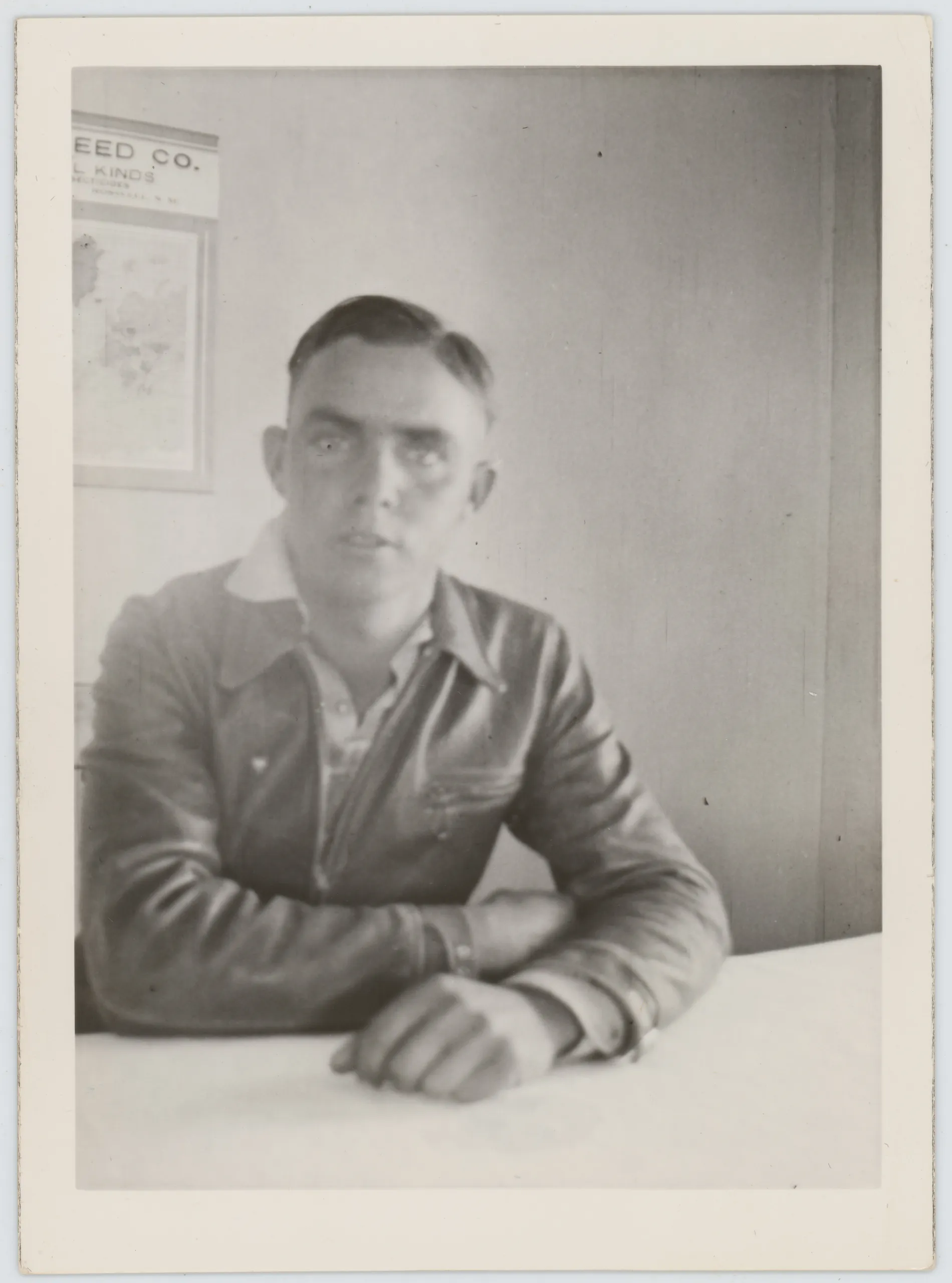 This photograph depicts Oscar Ingle Allison sitting at a table. There is a map or advertisement on the wall in the background that is partially visible. This sheet has a business from Roswell, New Mexico on it. This photograph predates Oscar's deployment to Europe, and it is likely from 1941 through 1943.