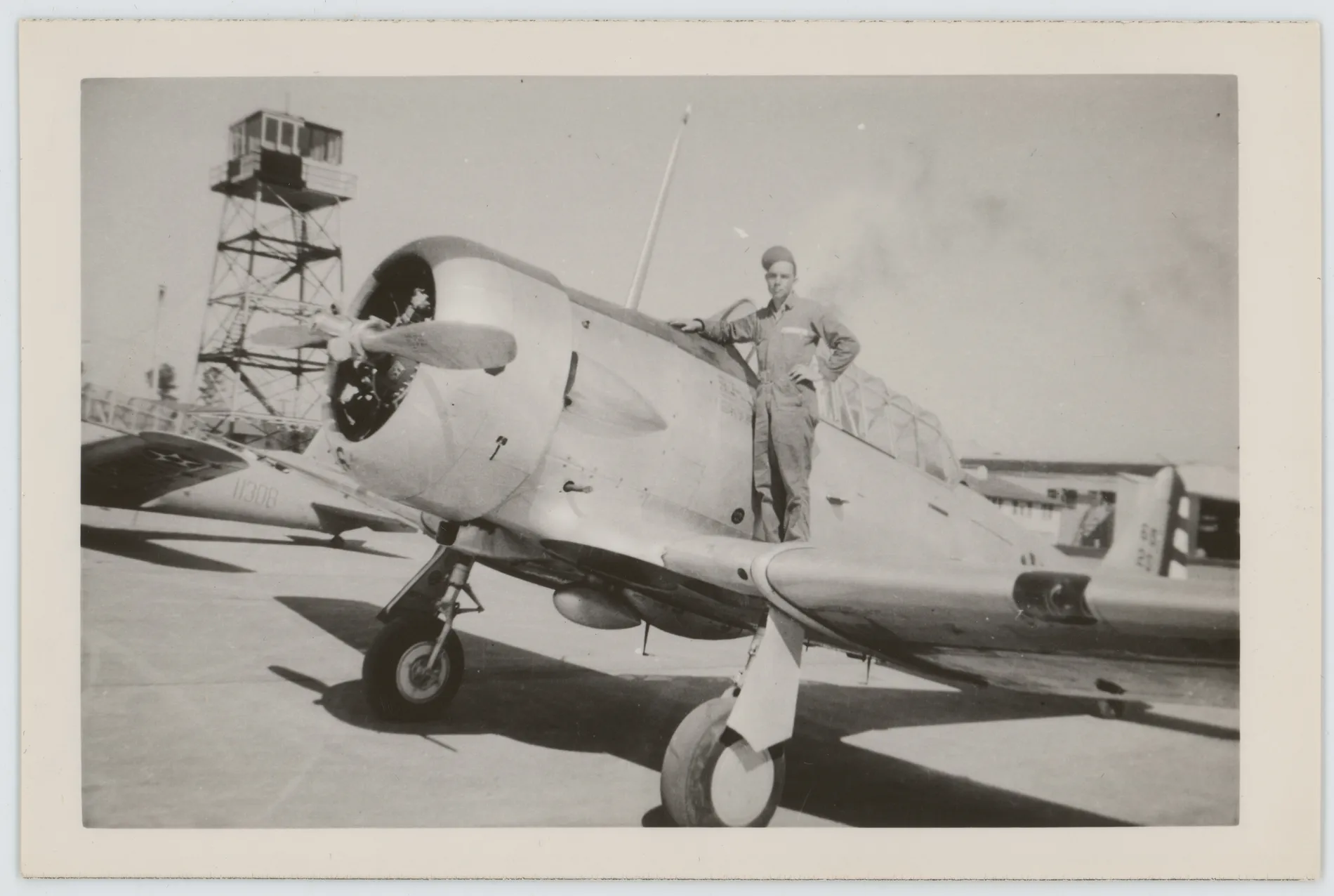 This photograph depicts Oscar Allison standing on the wing of an BT-13A Valiant aircraft during World War II. Oscar worked as a mechanic at Shaw Army Air Field between January 1942 and April 1943.
