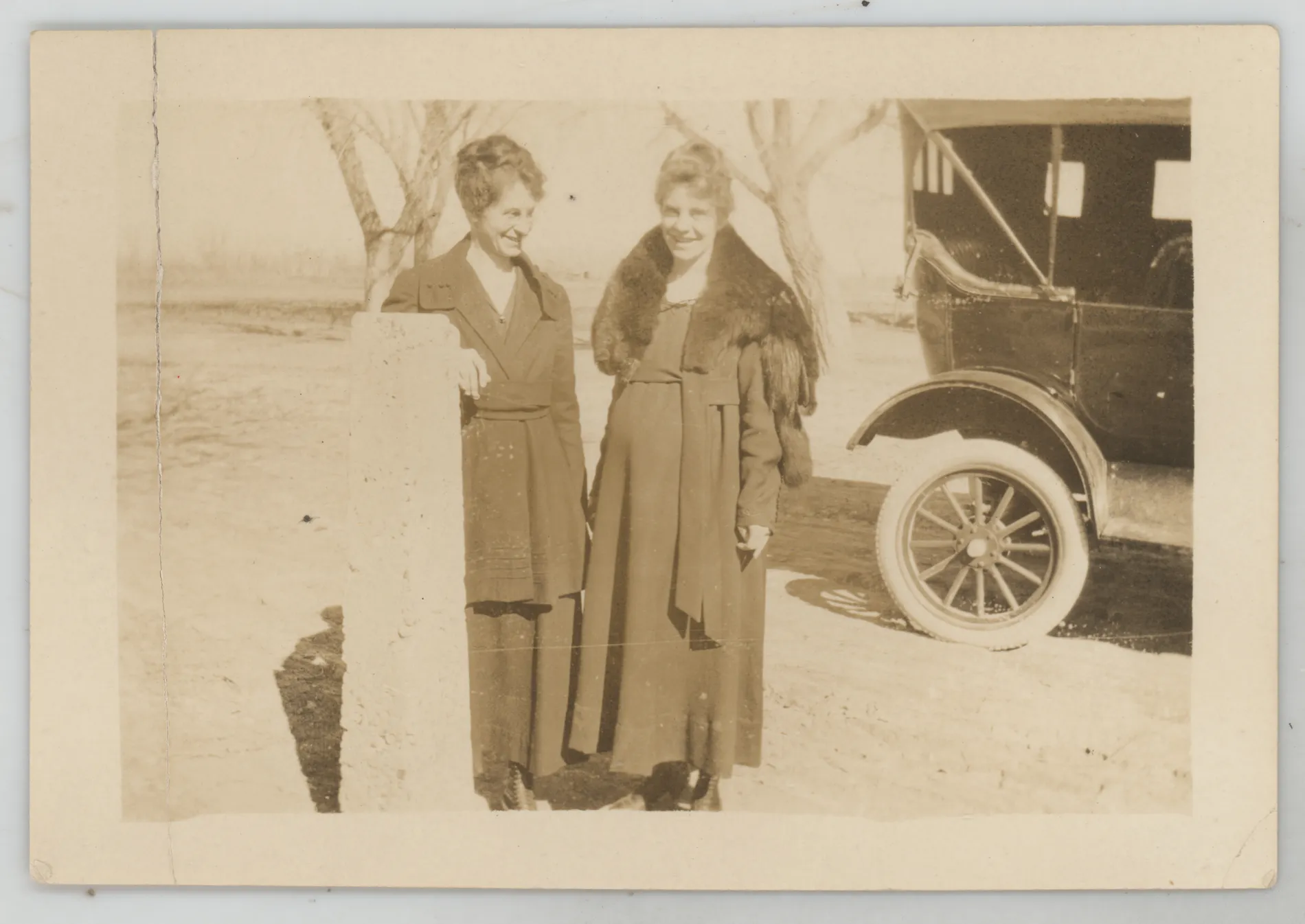 This photograph depicts sisters Loveta Swann McKinstry and Eva Swann West standing next to a car. Loveta appears pregnant in this image.