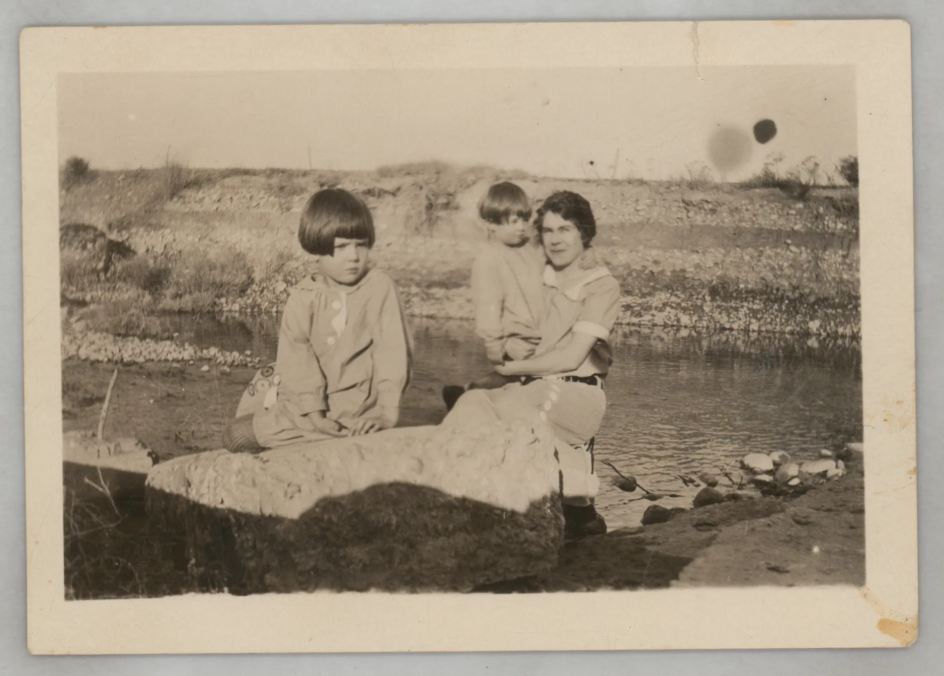 This photograph depicts Loveta McKinstry with her daughters, Sammy and Jean, on the banks of the Felix River sometime between 1923 and 1924.