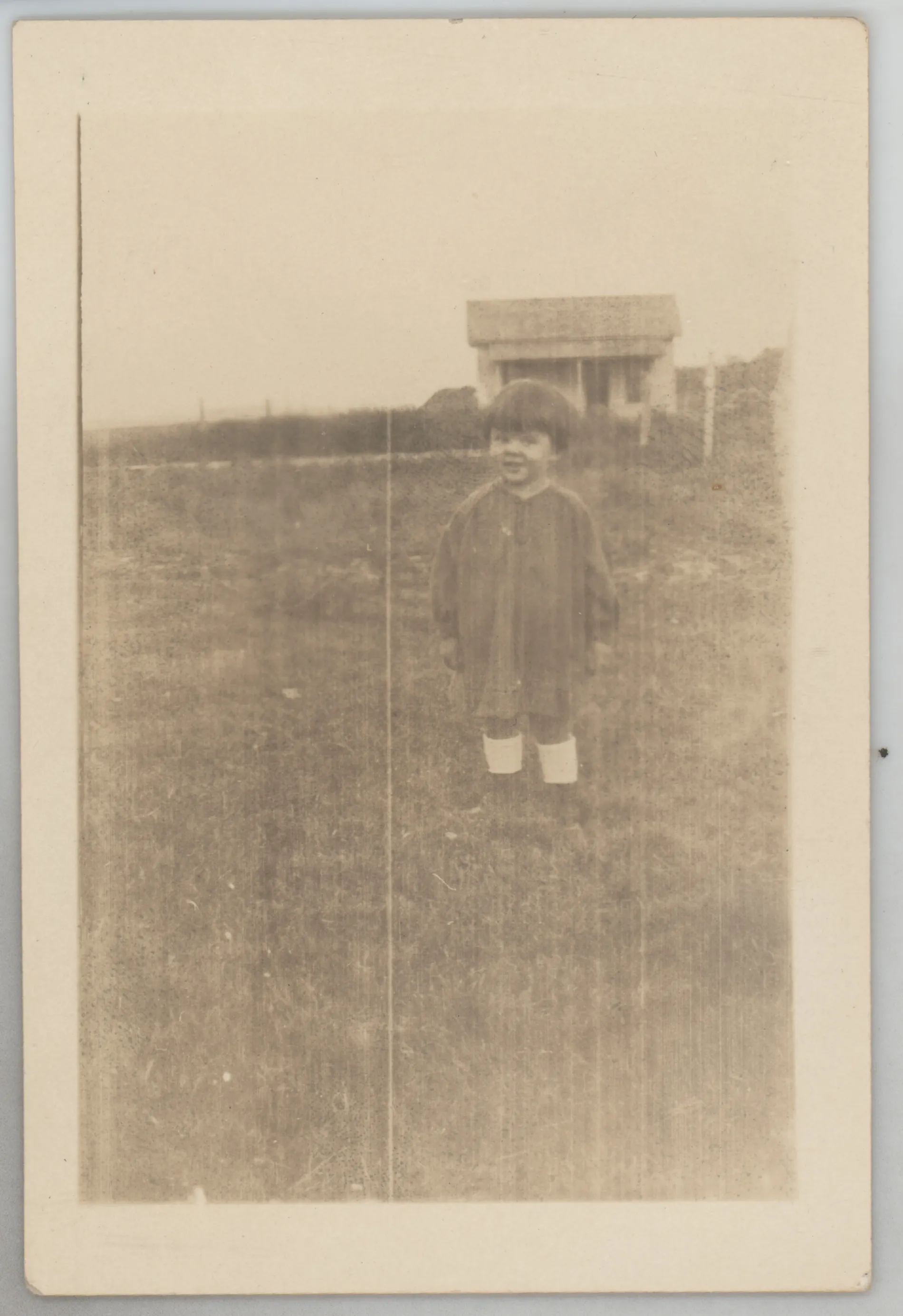 This photograph depicts Sammy McKinstry standing in a field in front of a shed or other structure.