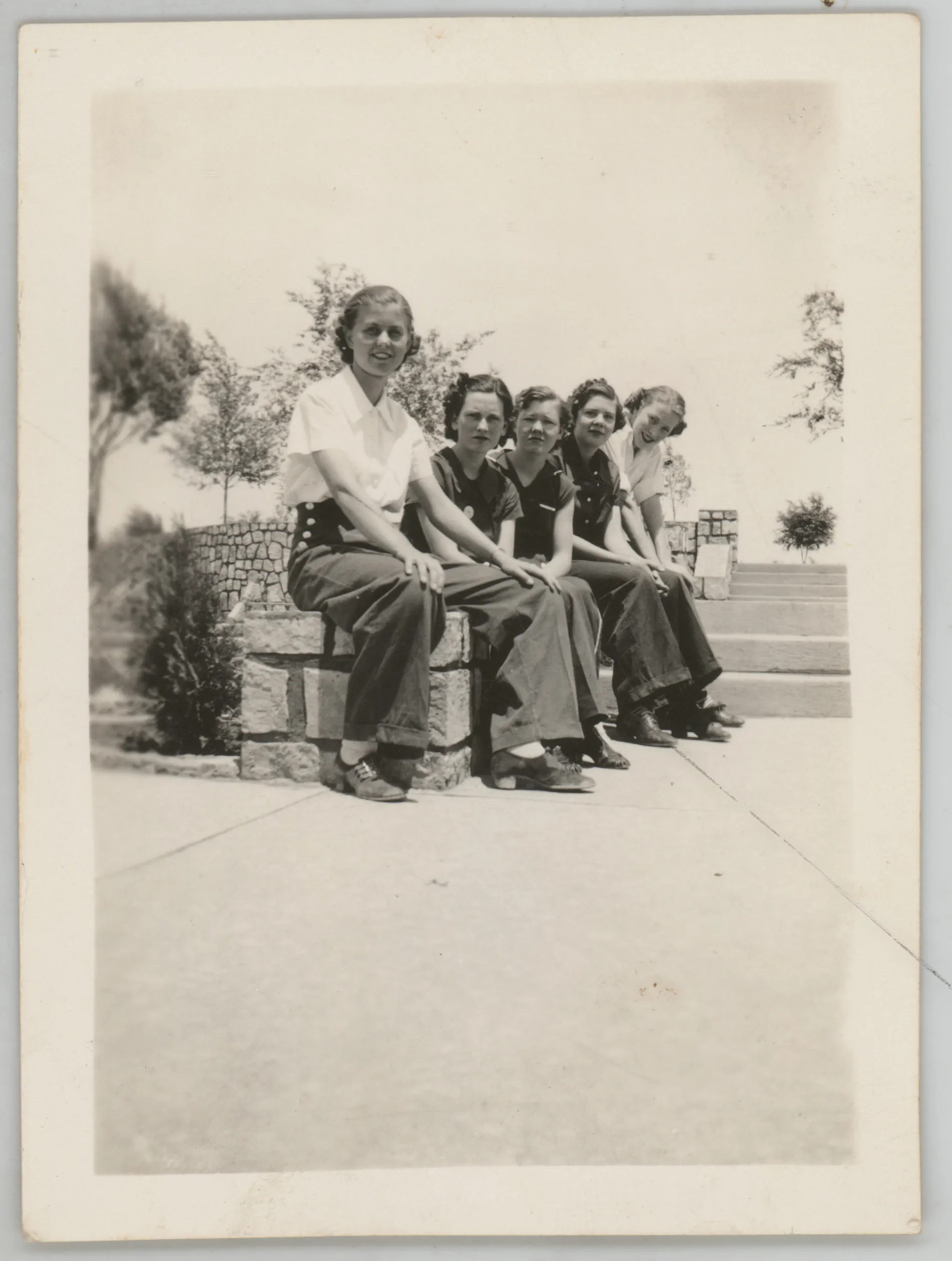 This photograph depicts Sammy McKinstry with a group of four unidentified friends sitting down on a bench. The location of this photograph is unknown, but it is likely from New Mexico.