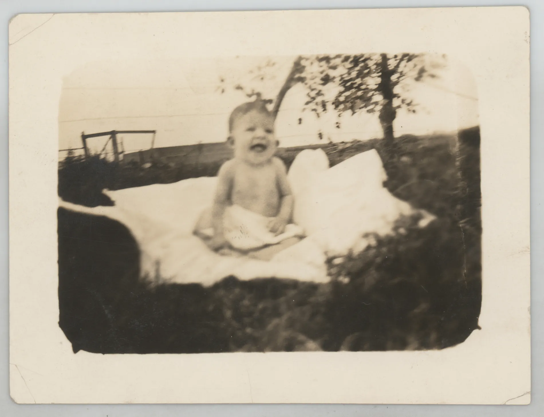 This photograph depicts an infant Sammy McKinstry sitting on a blanket outside.
