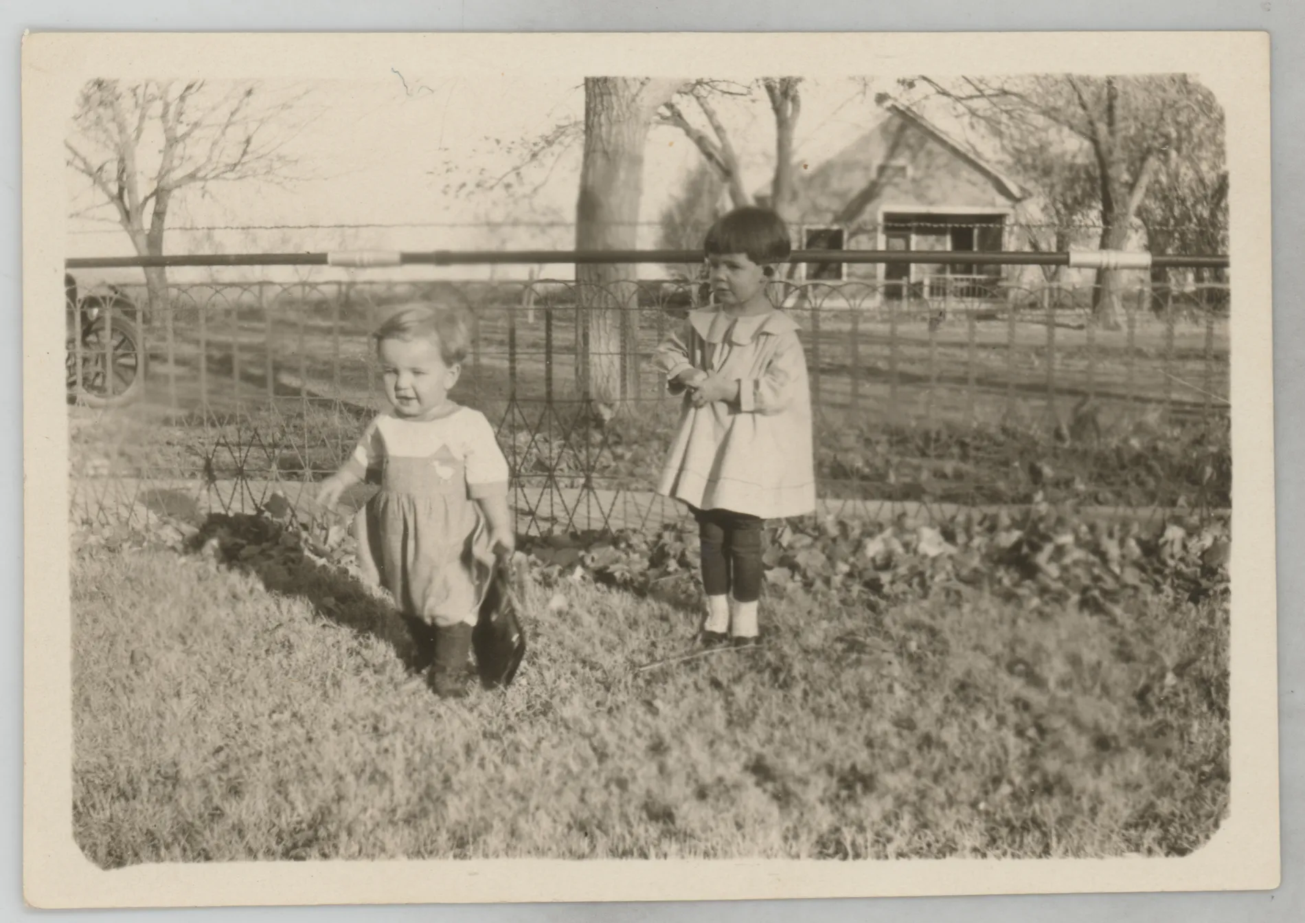 This photograph depicts Sammy McKinstry next to a fence with another unidentified child.