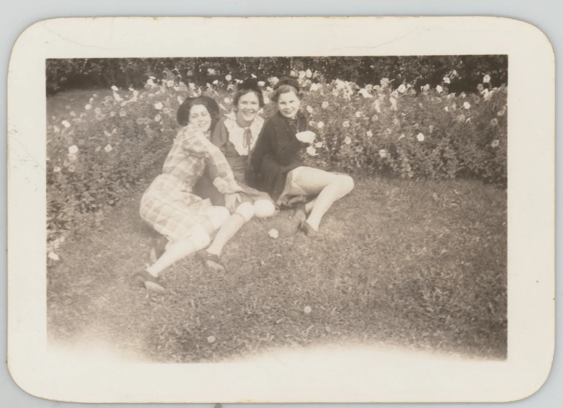 This photograph depicts Sammy McKinstry laying on the ground with two friends. This photogrpah may be from Sammy's time in Denver at Colorado Women's College. The stamp on the verso suggests it was taken or produced in Denver, Colorado.