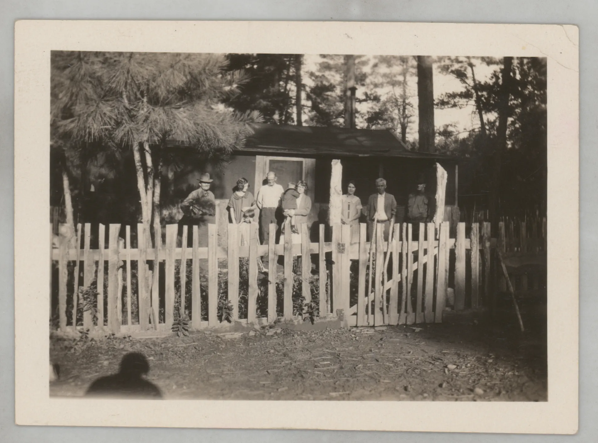 This photograph depicts various members of the Swann and McKinstry families standing outside a cabin.