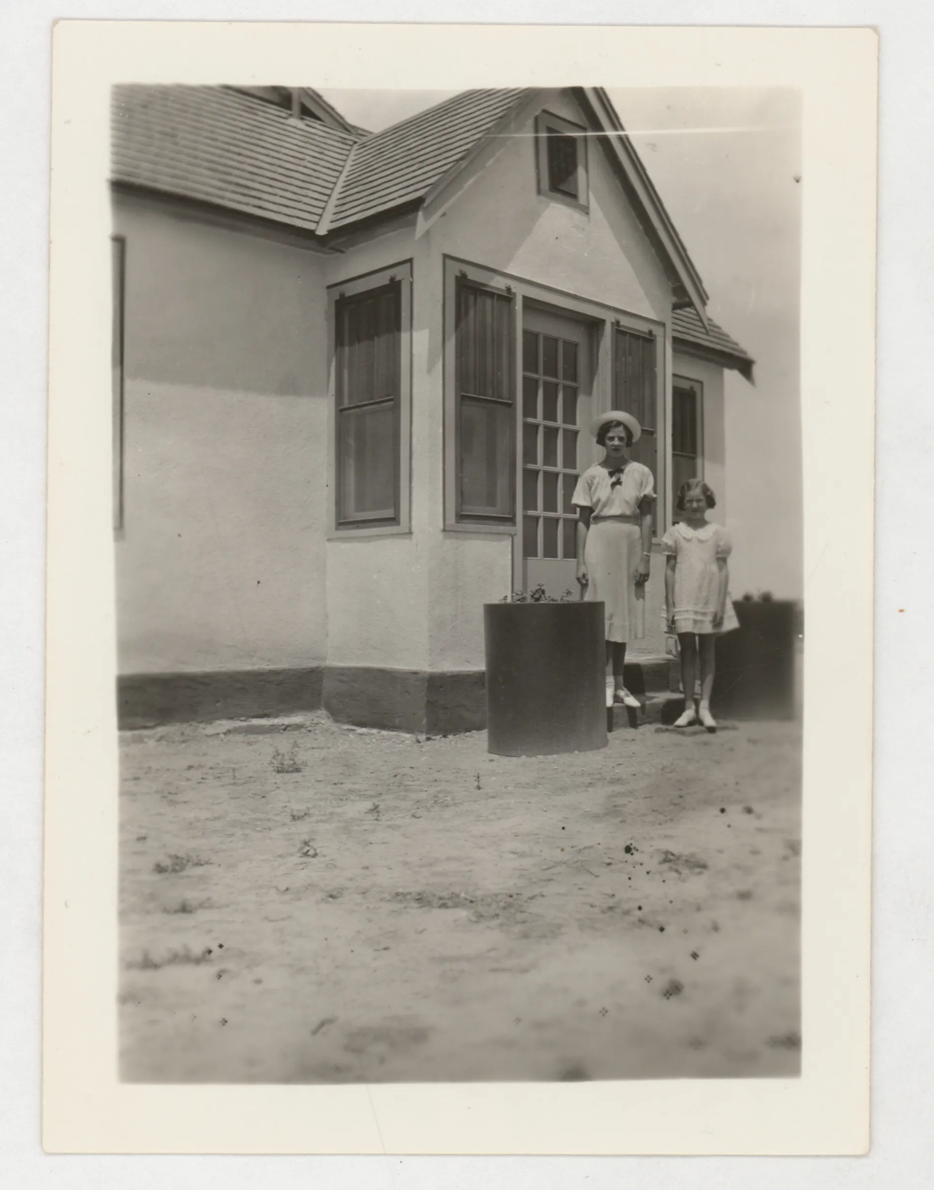 This photograph depicts Jean and Peggy McKinstry next to the Sam and Loveta McKinstry home in Hagerman, New Mexico.