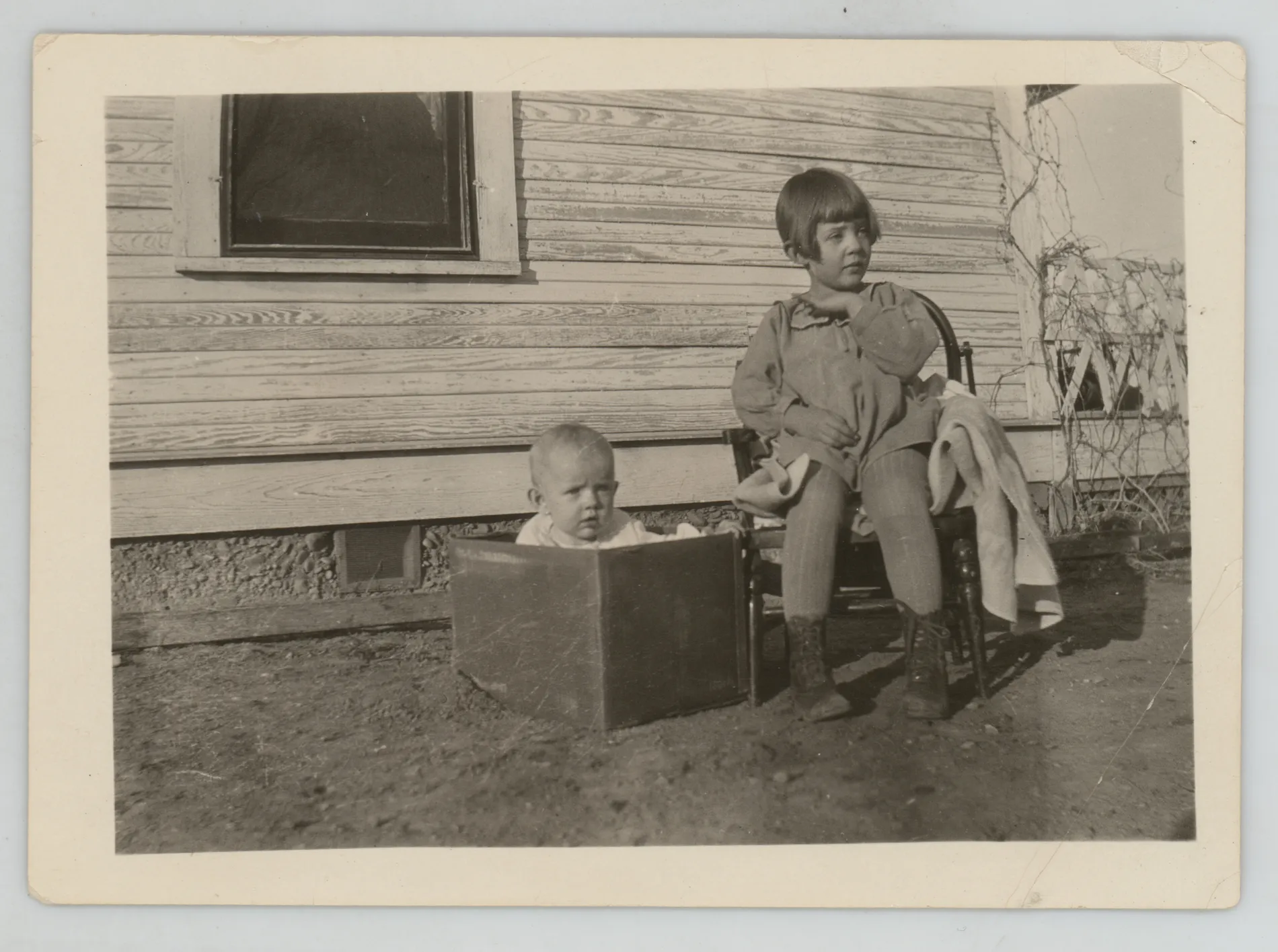 This photograph depicts Jean and Peggy McKinstry. Peggy is on the left in the box, and Jean is on the right sitting in the chair.