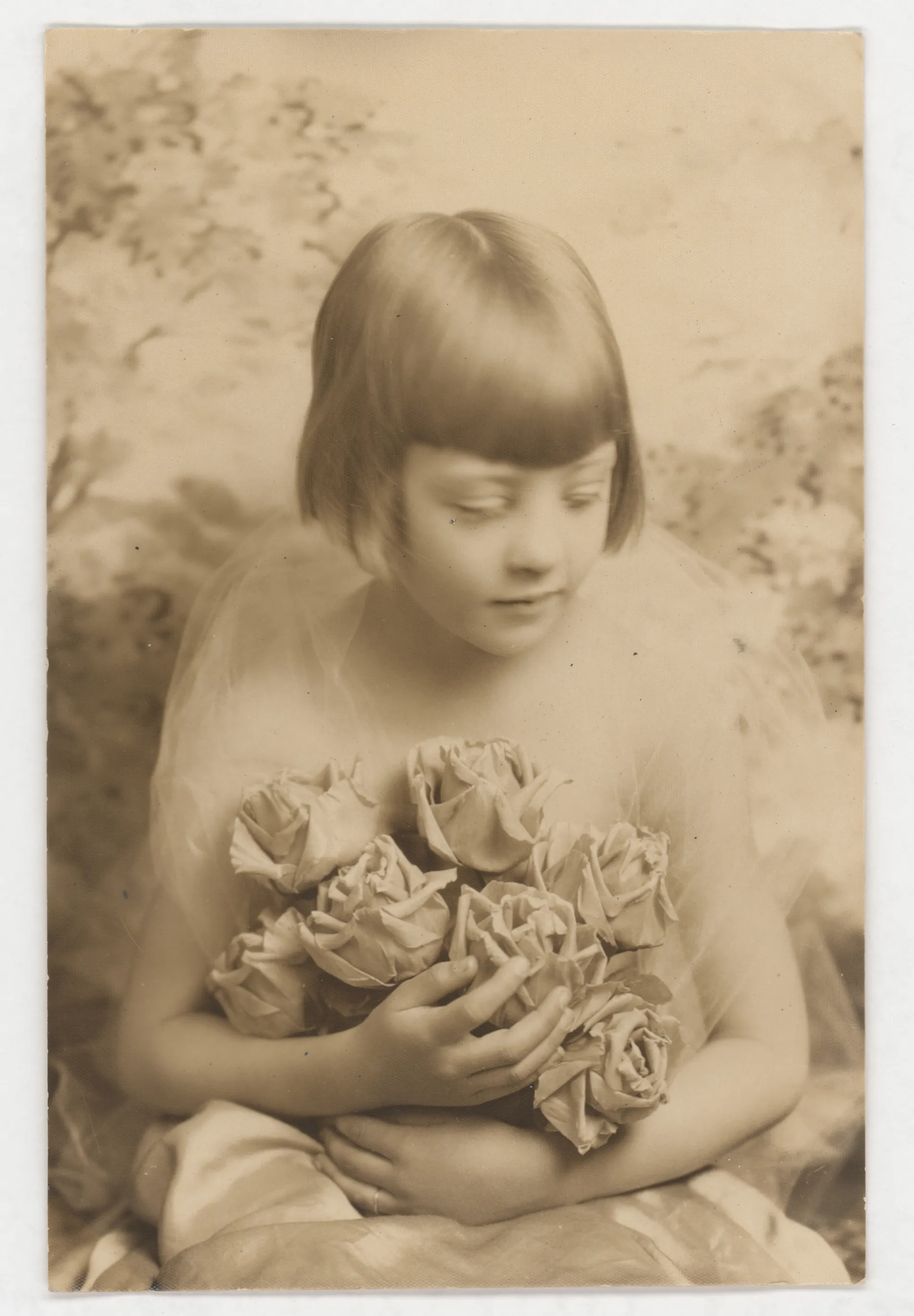 This is a portrait of Jean McKinstry from roughly 1927 or 1928. She is holding a bouqet of roses.