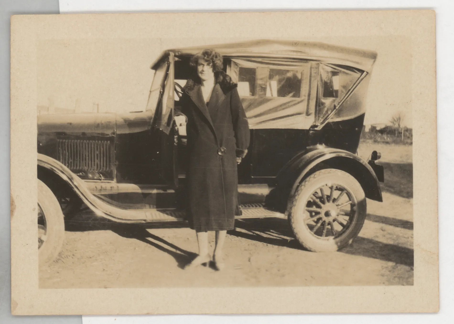 This photograph depicts Minnie Swann McKinstry next to a Ford car. The photograph is undated, but it was likely taken between 1925 and 1928 based on the age of Minnie and the model of the car.