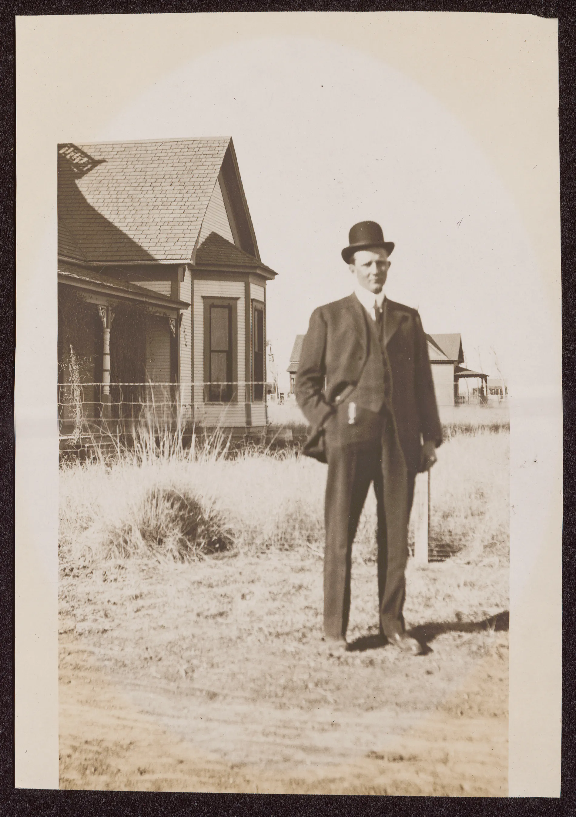 This photograph depicts Sam McKinstry standing next to a house. This could be from around the time he married Loveta Swann in November 1912, but this is not certain. He is wearing formal attire.