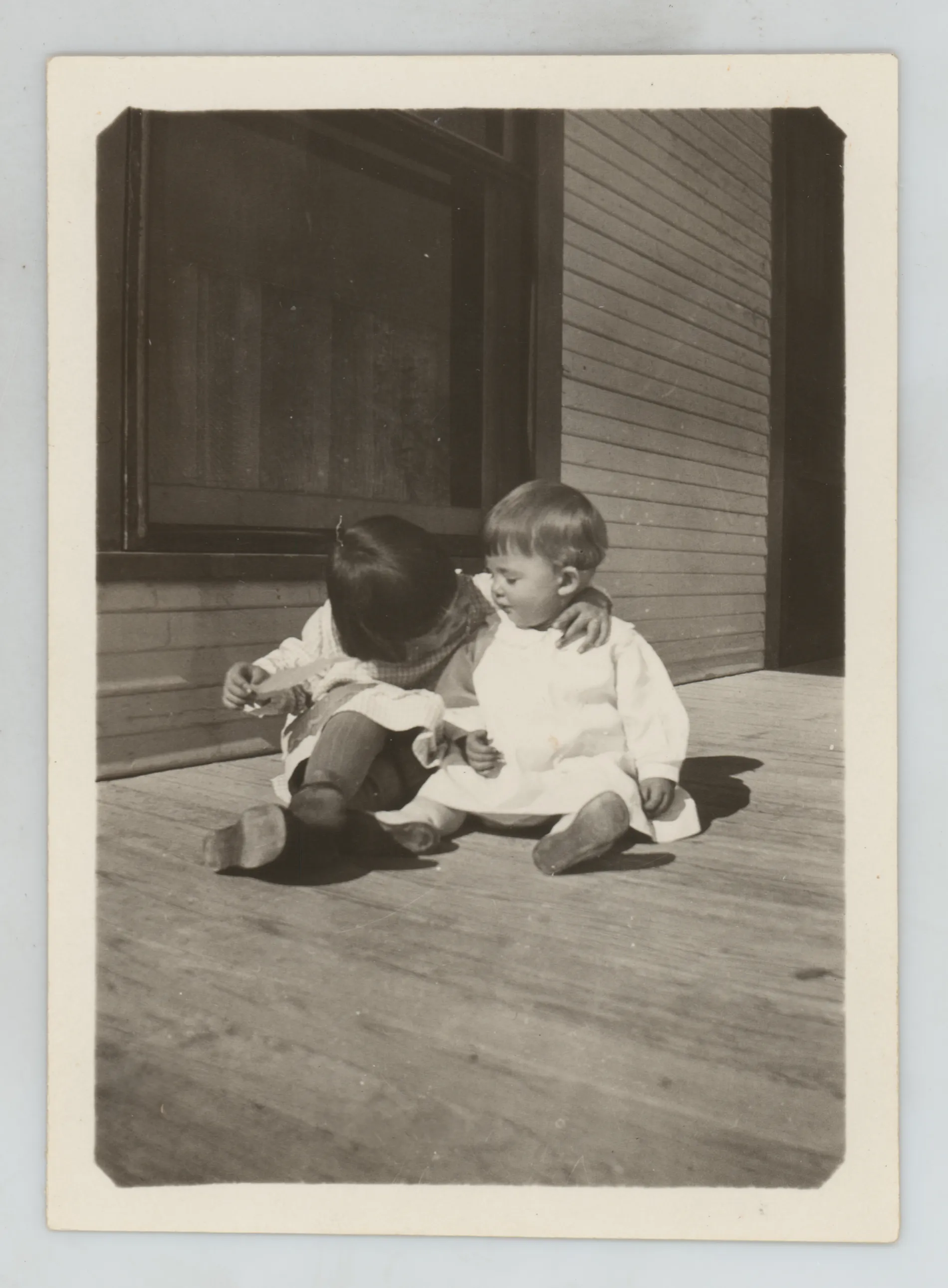 This photograph depicts Sammy and Jean McKinstry on a porch. Sammy is holding Jean around the neck.