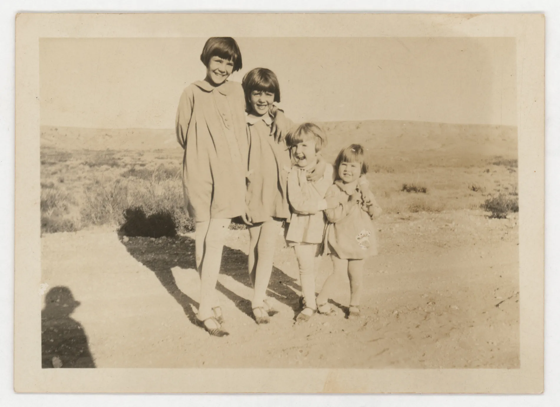 This photograph depicts Sammy, Jean, Peggy, and Mildred McKinstry. They are standing in the foreground of a mountain or ridge.
