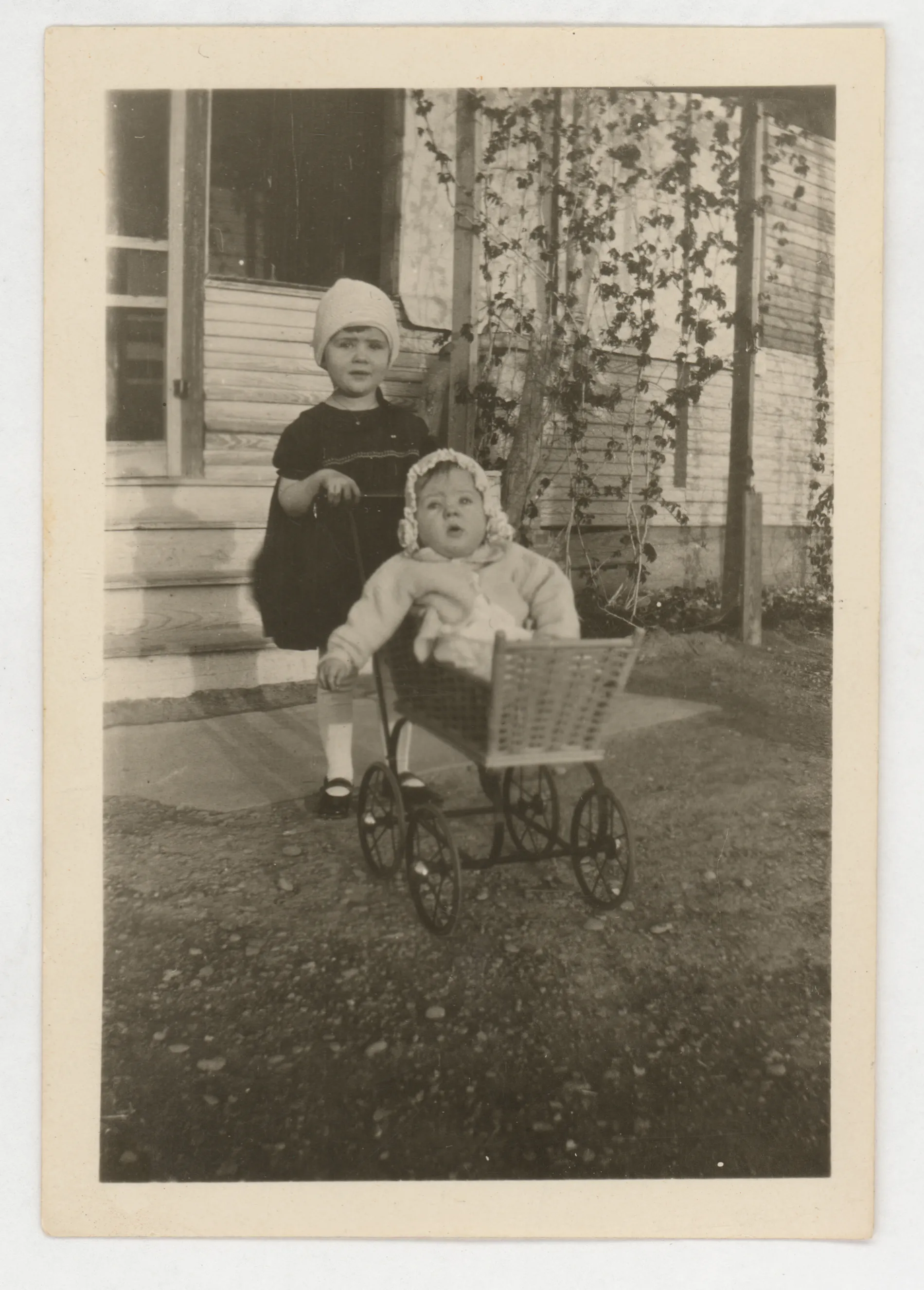 The photograph depicts Jean McKinstry in a stroller with Sammy McKinstry standing behind it as if pushing the stroller.