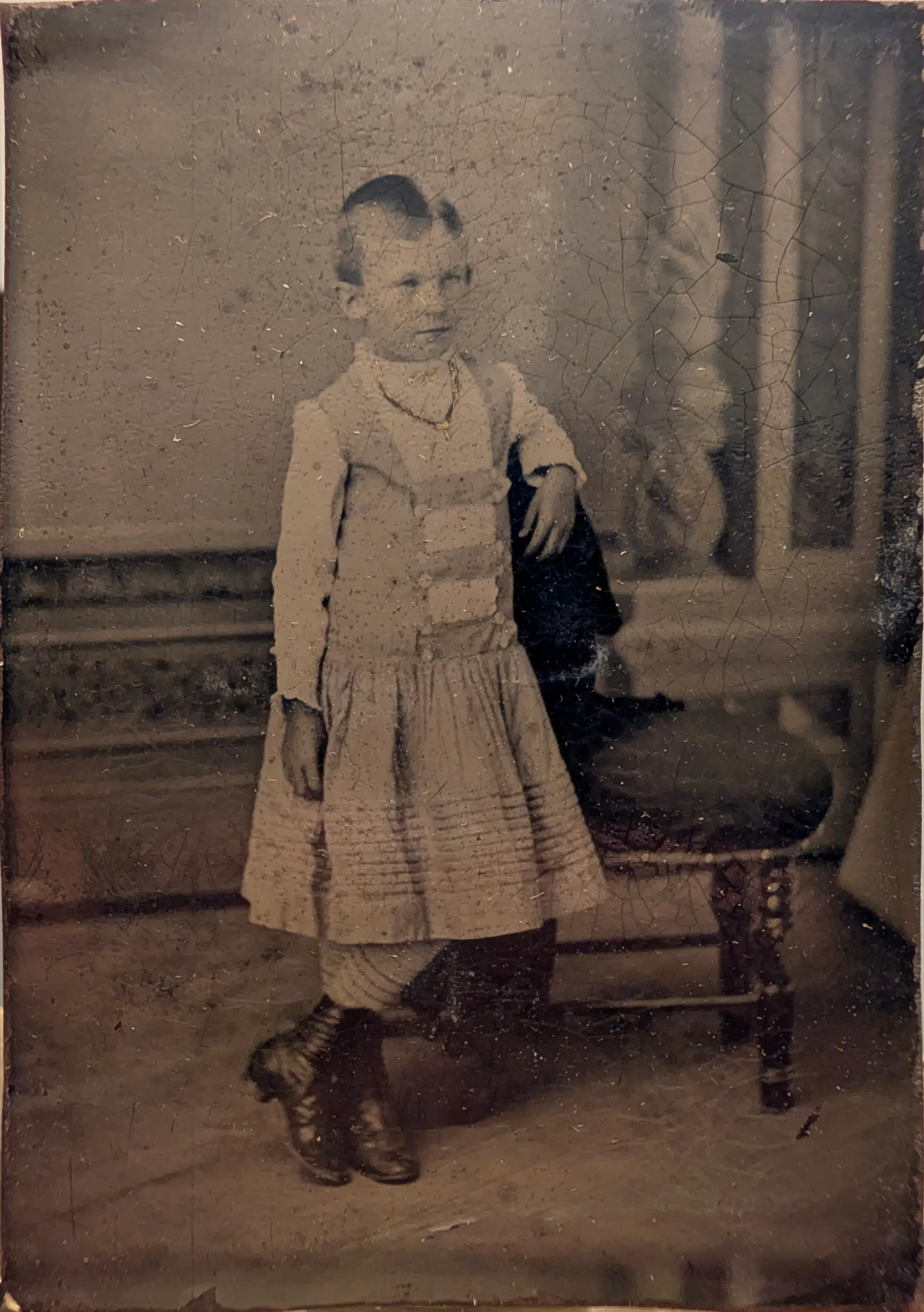 This is a photograph of a young Nannie Swann. Her age is estimated to be between 7 and 10 years old. This tintype is in a dual folding frame with a photograph of a young C.E. Girdner, whom she would later marry.