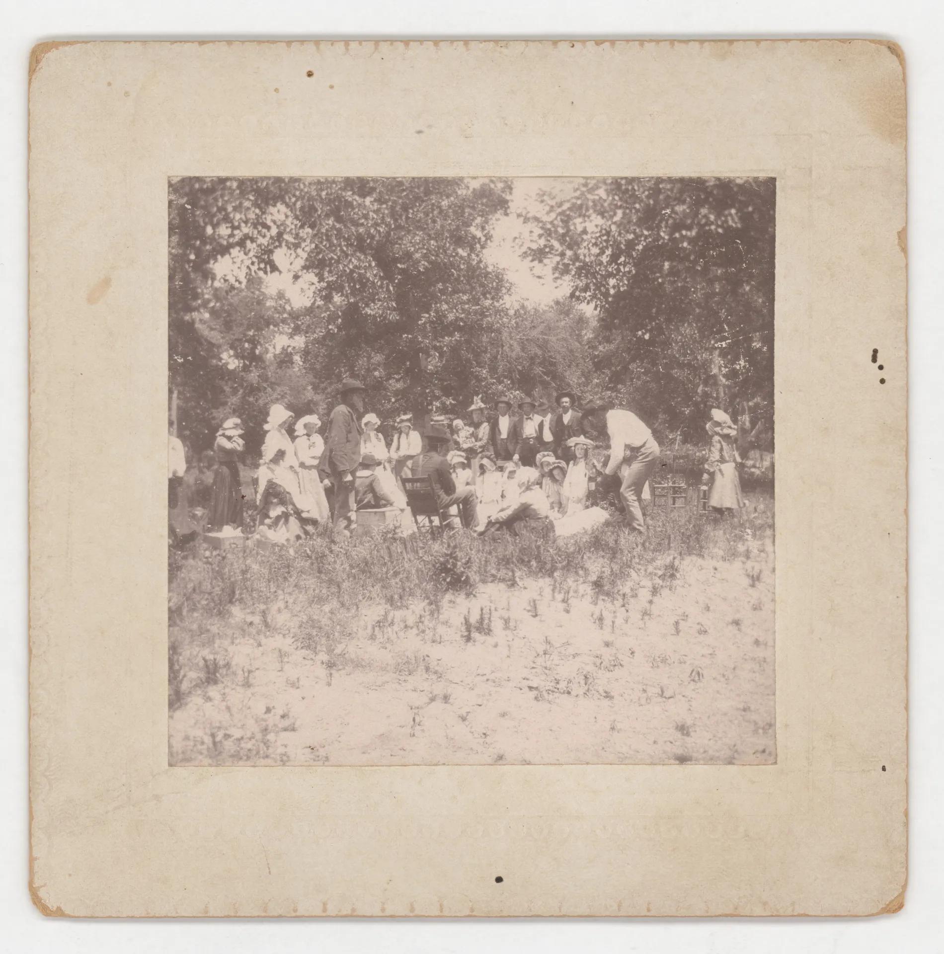 This photograph depicts a school picnic in Jacobia from approximately 1895. Individuals cannot be identified from the picture, although an older Malcom Swann may be standing left of center with a beard.