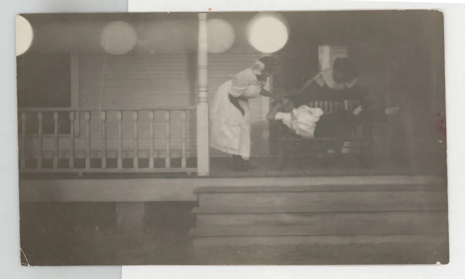 This photograph depicts Eva Swann, Minnie Swann, and Loveta Swann on the porch of their Hagerman, New Mexico home. No specific identifications are possible.