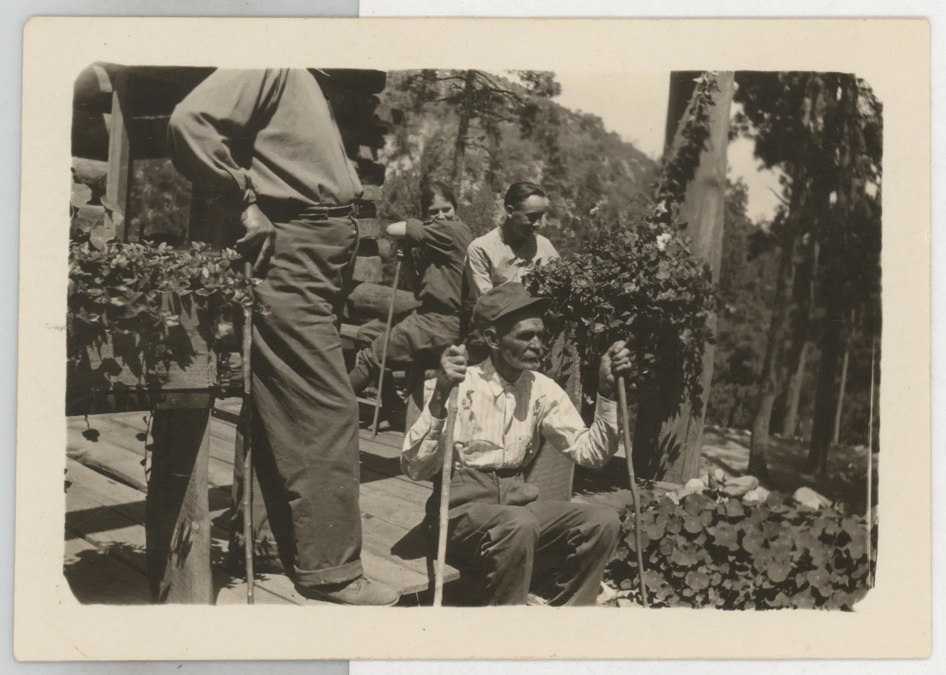 This photograph depicts Austin Swann sitting on a porch. Jim McKinstry is left and Edmund McKinstry is in the back.