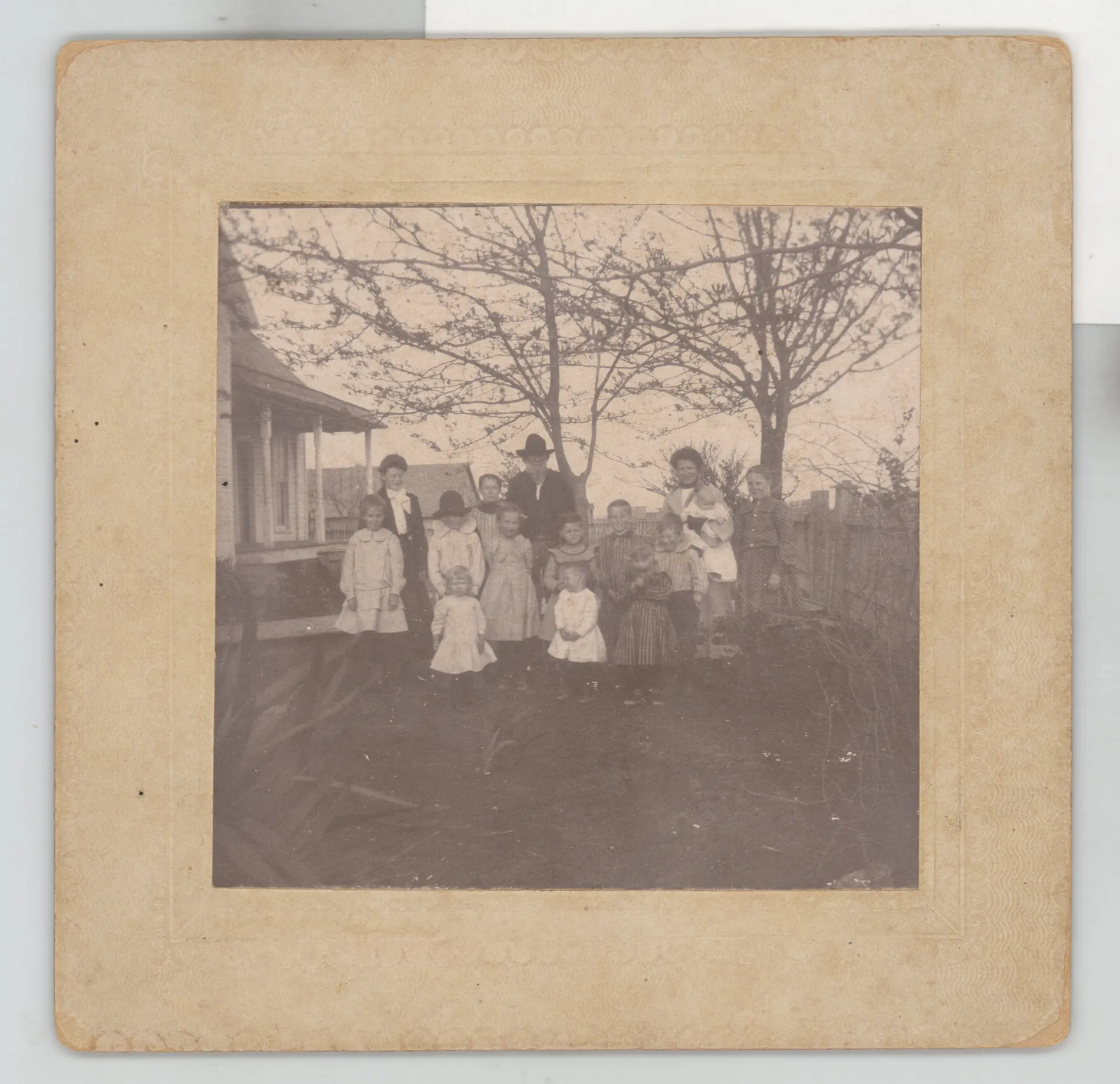 This photograph depicts Malcom Swann standing in the yard of a home at Jacobia, Texas with several of his grandchildren.