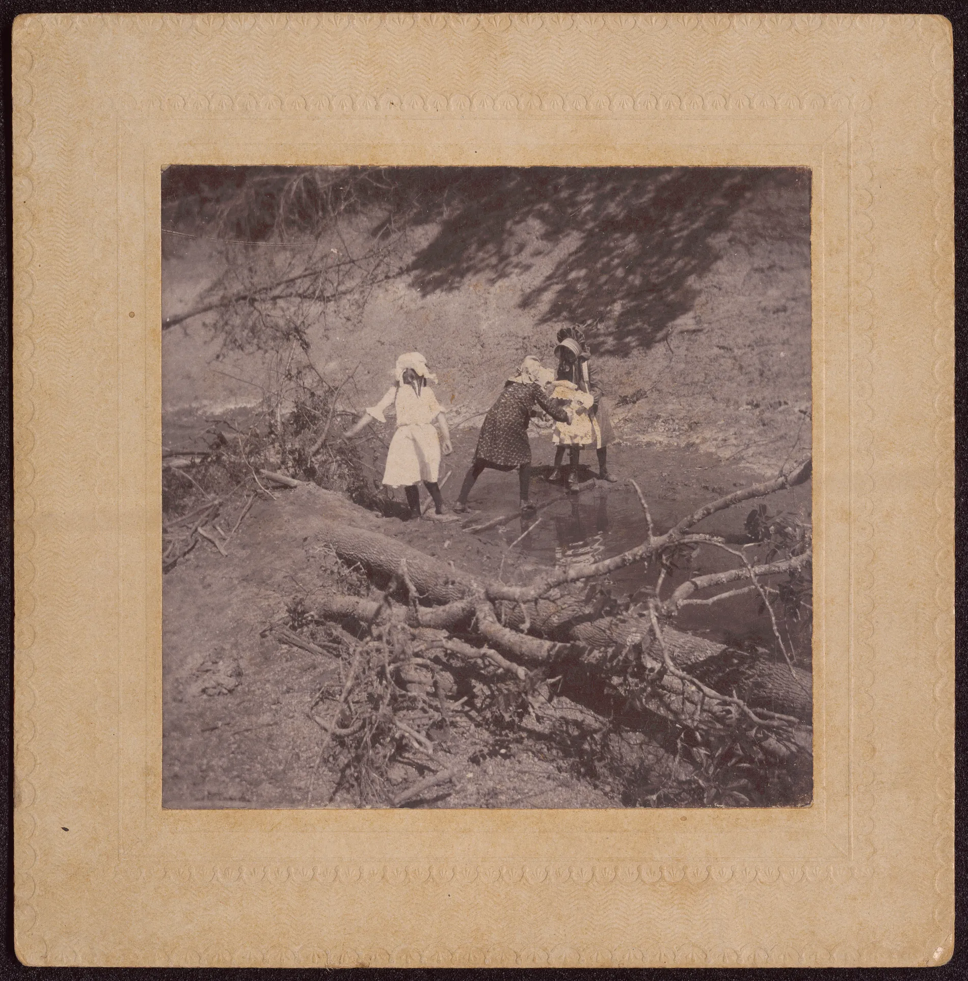 This photograph depicts four children crossing a stream, possibly the North Canadian River somewhere in Oklahoma. Positive identifications are impossible, but it can be guessed that Zera Girdner is on the left and the next person on the right is Minnie Swann.