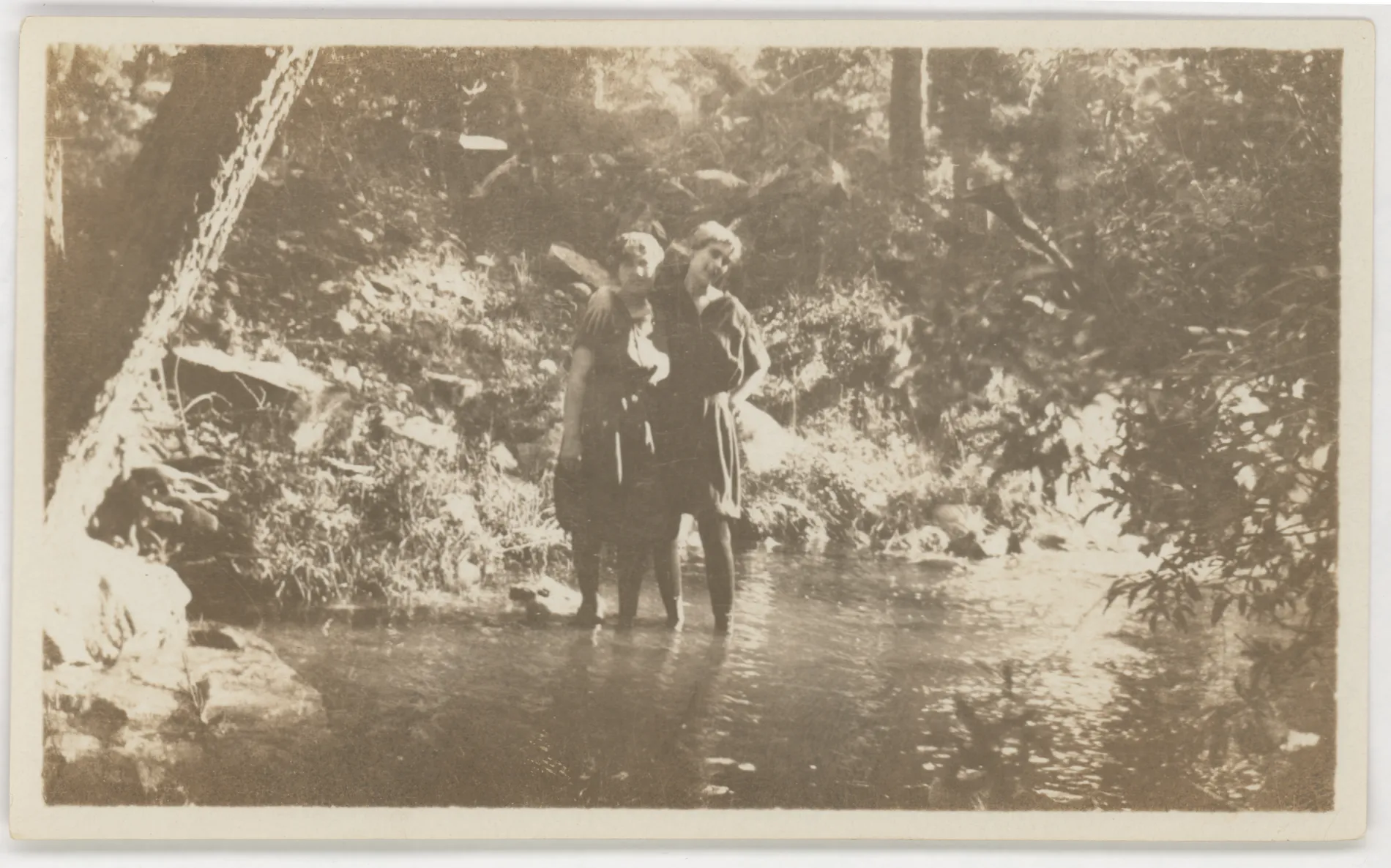 This photograph depicts two women standing in a stream. The woman on the right may be Minnie Swann McKinstry, but the photo is too blurry to definitively know.