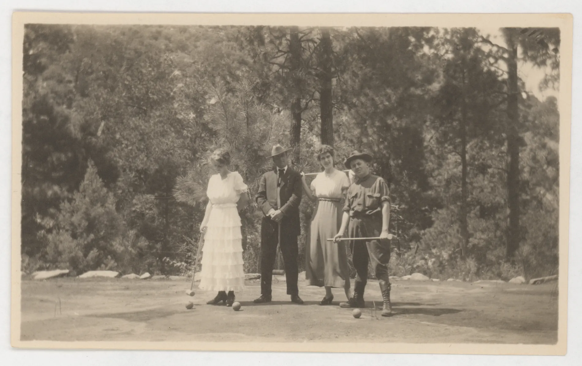 This photograph depicts two women and two men playing croquet in a mountain environment. This photograph may be related to another one taken in similar settings.